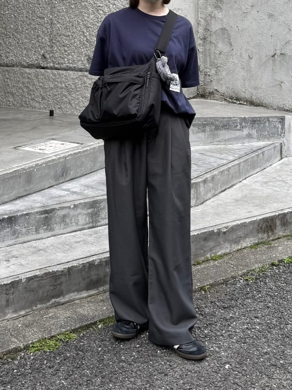 ブルー系のTシャツ/カットソー、グレー系のスラックス、ブラック系のショルダーバッグを着用したレディースの夏コーディネートの2枚目の写真