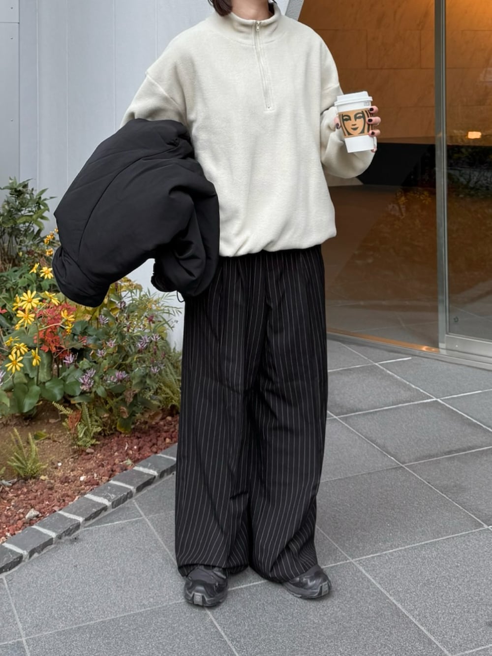 ホワイト系のスウェット、ブラック系のスラックス、ブラック系のスニーカーを着用したレディースの冬コーディネートの2枚目の写真