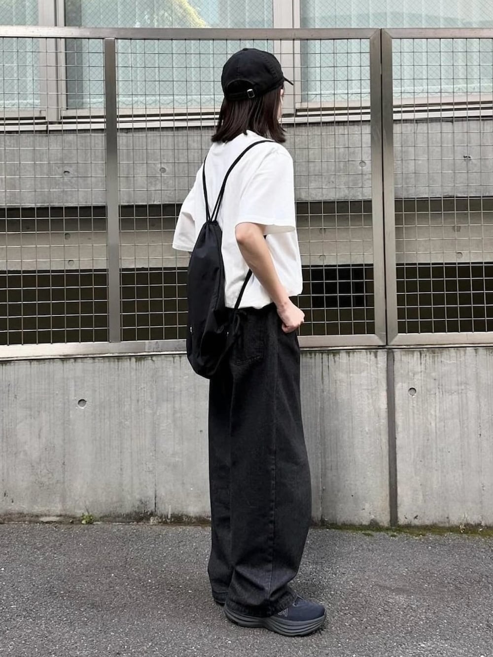 ホワイト系のTシャツ/カットソー、ブラック系のデニムパンツ、ブラック系のショルダーバッグを着用したレディースの夏コーディネートの2枚目の写真