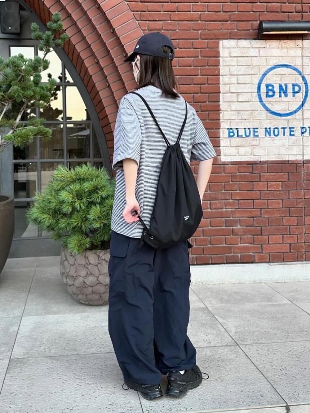 グレー系のTシャツ/カットソー、ブルー系のカーゴパンツ、ブラック系のショルダーバッグを着用したレディースの夏コーディネートの3枚目の写真