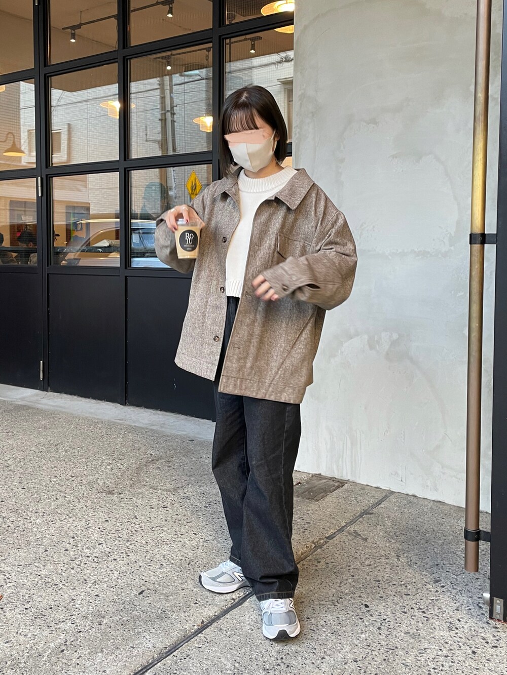 ブラウン系のシャツ/ブラウス、ベージュ系のニット/セーター、ブラック系のデニムパンツを着用したレディースの秋コーディネートの2枚目の写真