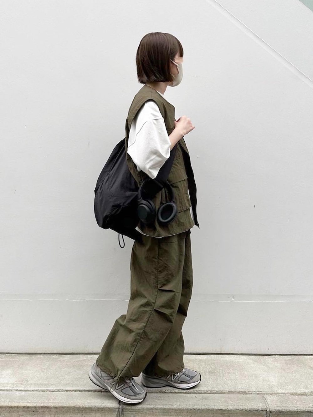 グリーン系のベスト、グリーン系のその他パンツ、グレー系のスニーカーを着用したレディースの春コーディネートの2枚目の写真