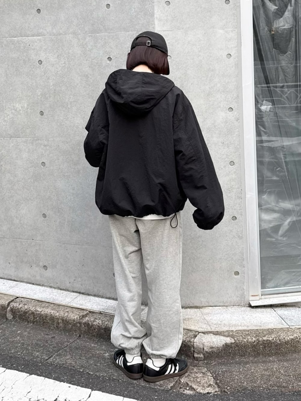 ブラック系のパーカー、グレー系のスウェットパンツ、ブラック系のスニーカーを着用したレディースの冬コーディネートの3枚目の写真