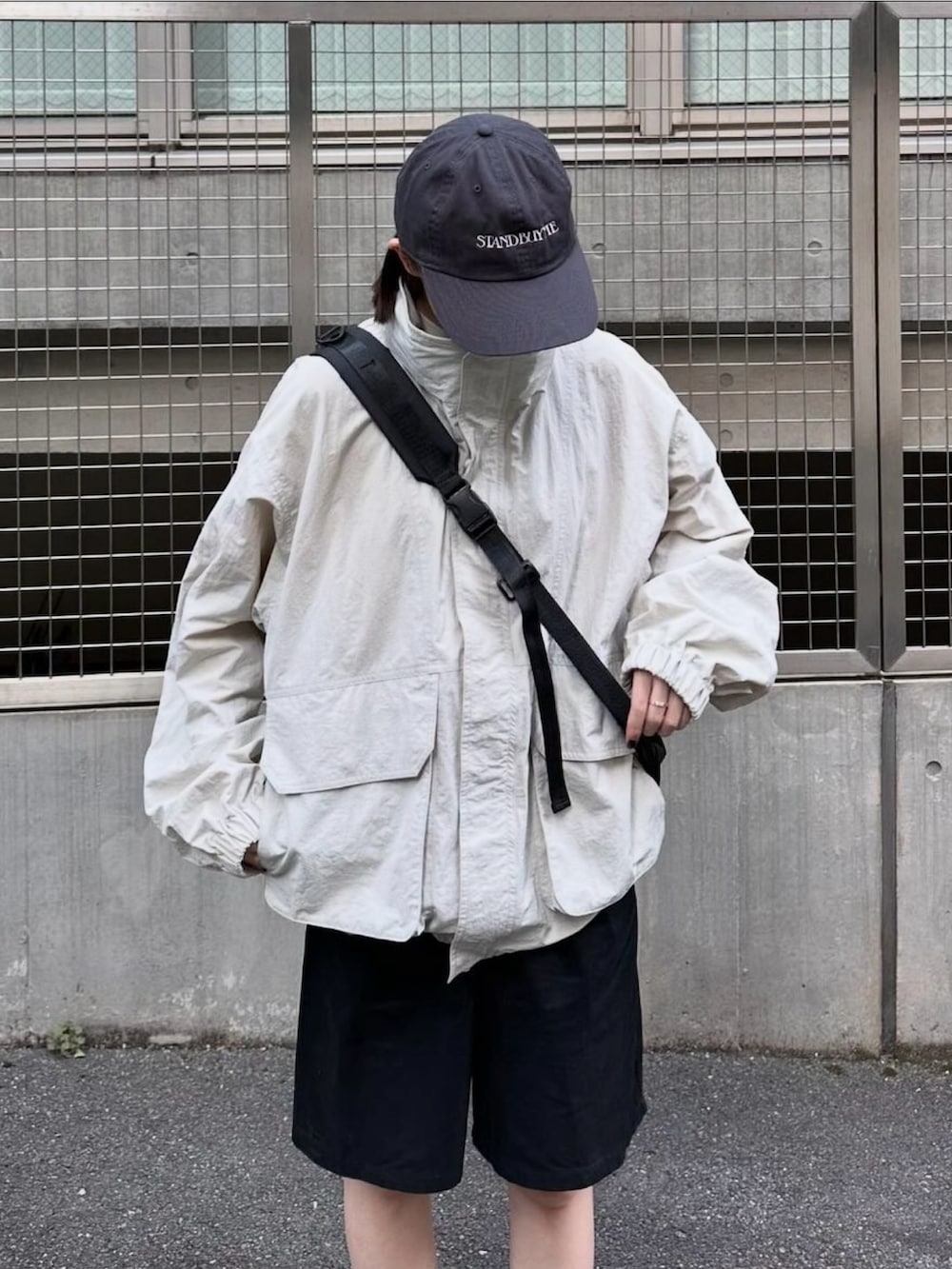 ホワイト系のマウンテンパーカー、ブラック系のその他パンツ、ブラック系のショルダーバッグを着用したレディースの秋コーディネートの3枚目の写真