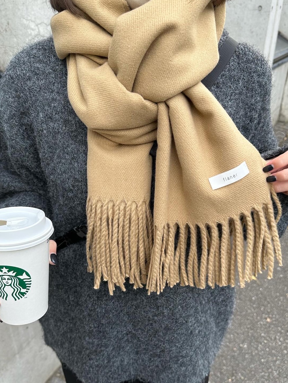 グレー系のニット/セーター、ブラック系のスラックス、ホワイト系のスニーカーを着用したレディースの冬コーディネートの2枚目の写真