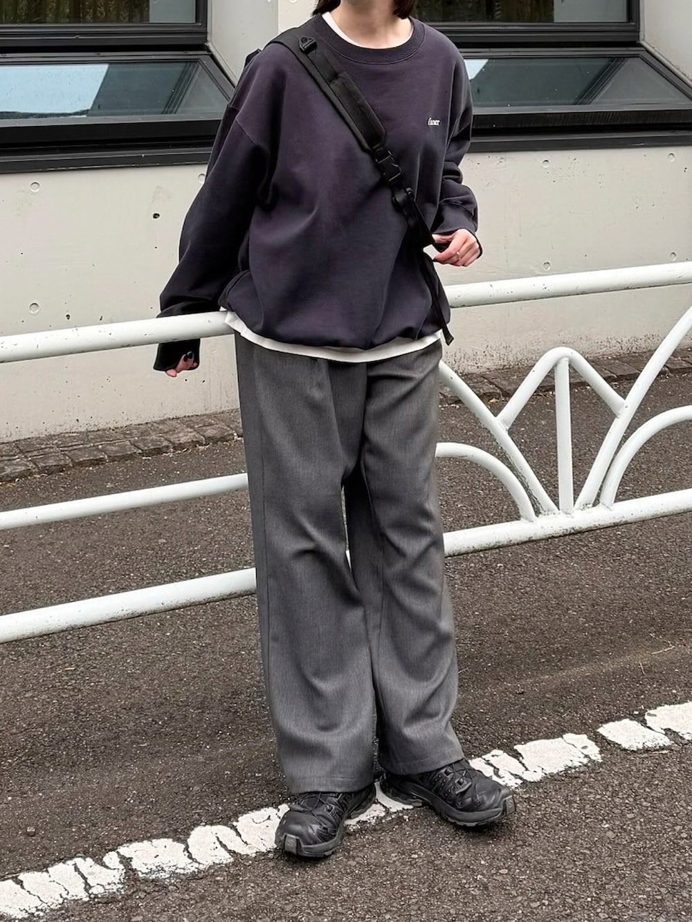 ブルー系のスウェット、グレー系のスラックス、ブラック系のショルダーバッグを着用したレディースの冬コーディネートの2枚目の写真