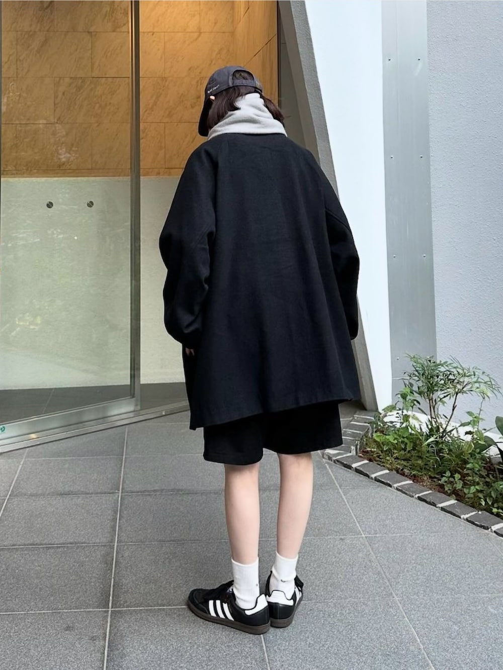 ブラック系のステンカラーコート、ブラック系のその他パンツ、ブラック系のスニーカーを着用したレディースの秋コーディネートの4枚目の写真