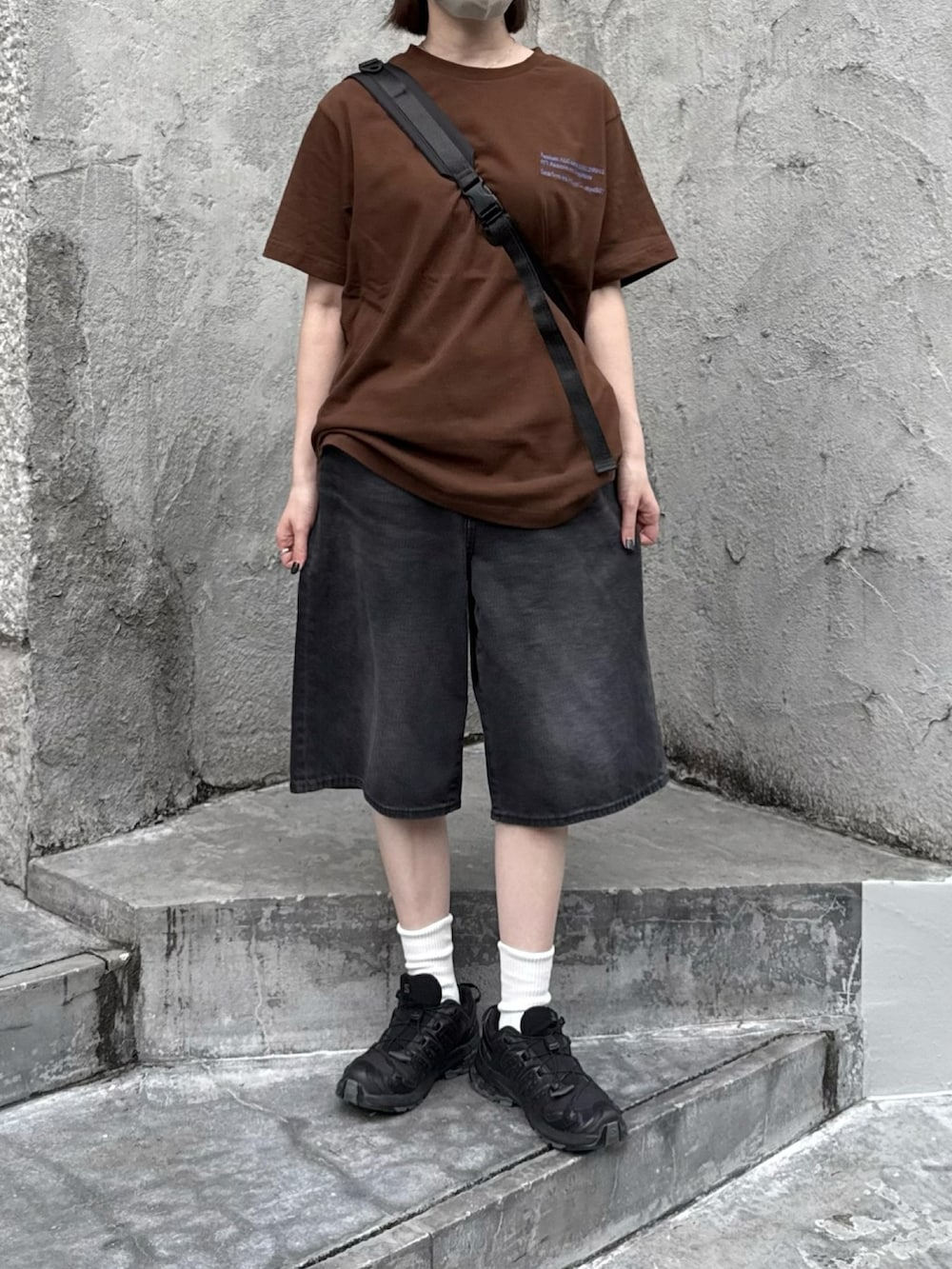 ブラウン系のTシャツ/カットソー、ブラック系のスニーカー、ブラック系のショルダーバッグを着用したレディースの夏コーディネートの2枚目の写真