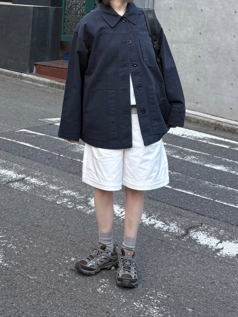 グレー系のスニーカー、ブルー系のミリタリージャケット、ホワイト系のその他パンツを着用したレディースの春コーディネートの2枚目の写真