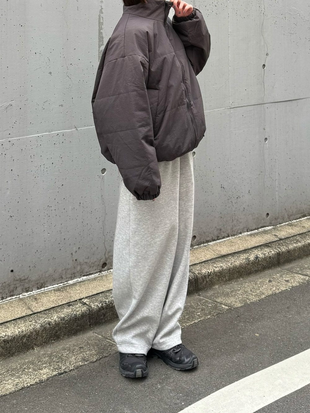 ブラック系のスニーカー、ブラック系のショルダーバッグ、グレー系のスウェットパンツを着用したレディースの秋コーディネートの2枚目の写真