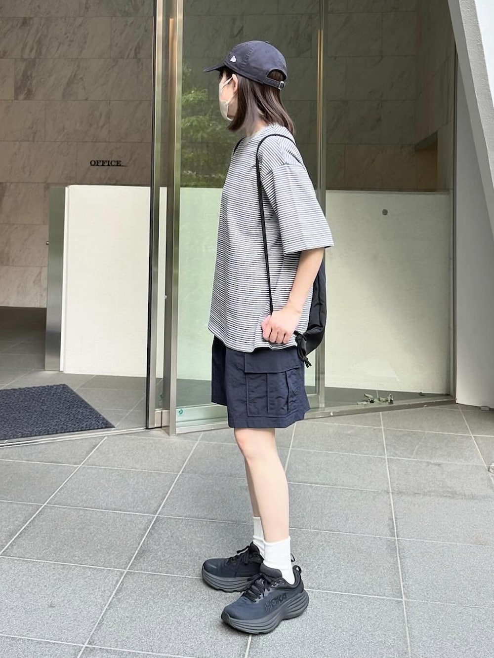 グレー系のTシャツ/カットソー、ブルー系のカーゴパンツ、ブラック系のスニーカーを着用したレディースの春コーディネートの3枚目の写真