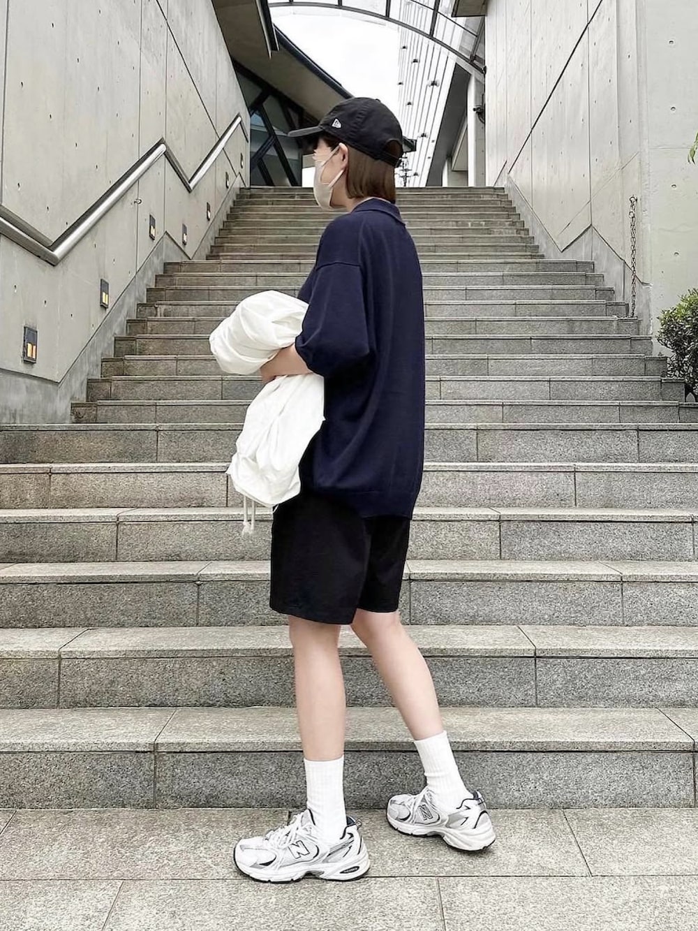 ブルー系のポロシャツ、ブラック系のその他パンツ、ホワイト系のスニーカーを着用したレディースの夏コーディネートの2枚目の写真
