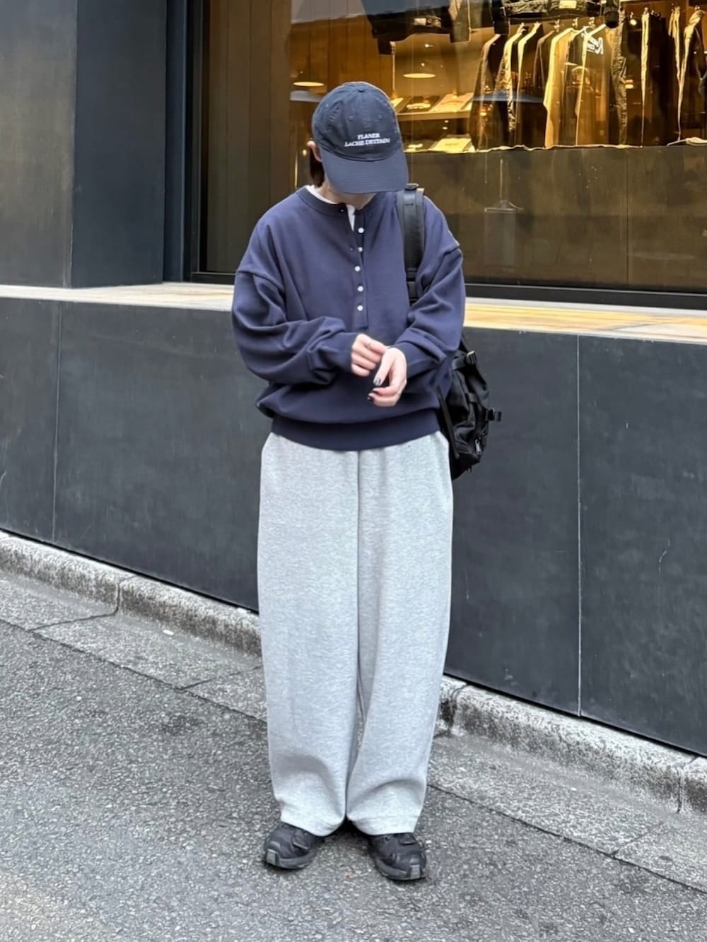 ブルー系のニット/セーター、ブラック系のスニーカー、ブラック系のショルダーバッグを着用したレディースの春コーディネートの2枚目の写真