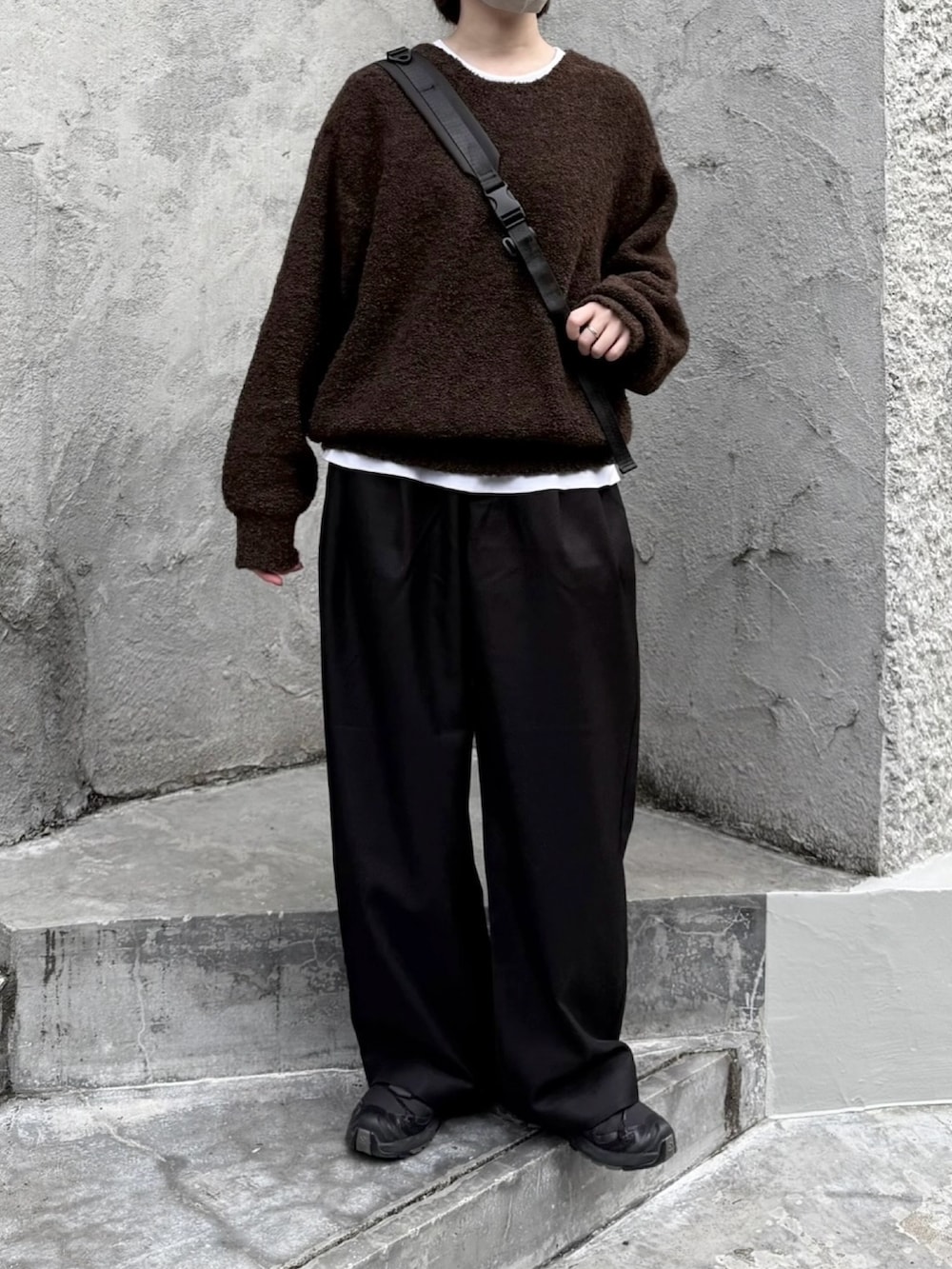 ブラック系のスニーカー、ブラック系のショルダーバッグ、ブラウン系のニット/セーターを着用したレディースの秋コーディネートの2枚目の写真