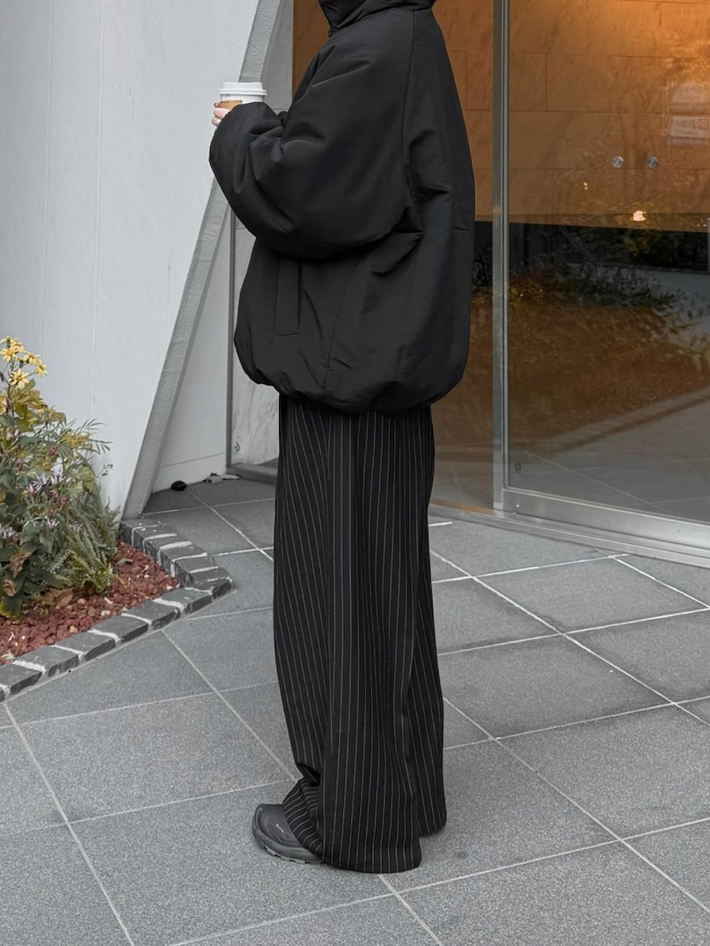 ブラック系のその他アウター、ブラック系のスラックス、ブラック系のスニーカーを着用したレディースの冬コーディネートの3枚目の写真