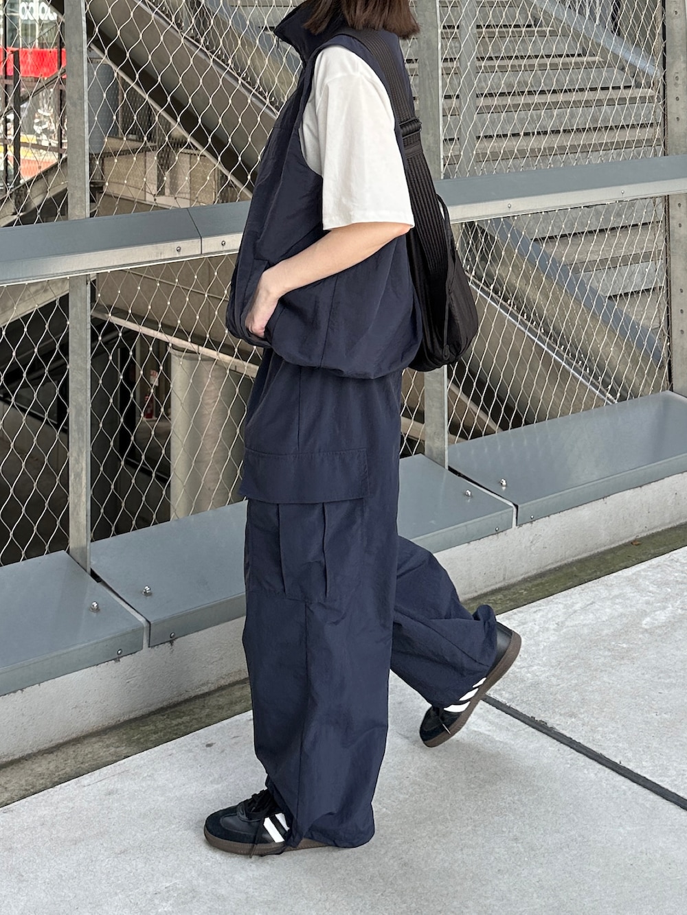 ブルー系のベスト、ホワイト系のTシャツ/カットソー、ブルー系のカーゴパンツを着用したレディースの夏コーディネートの2枚目の写真