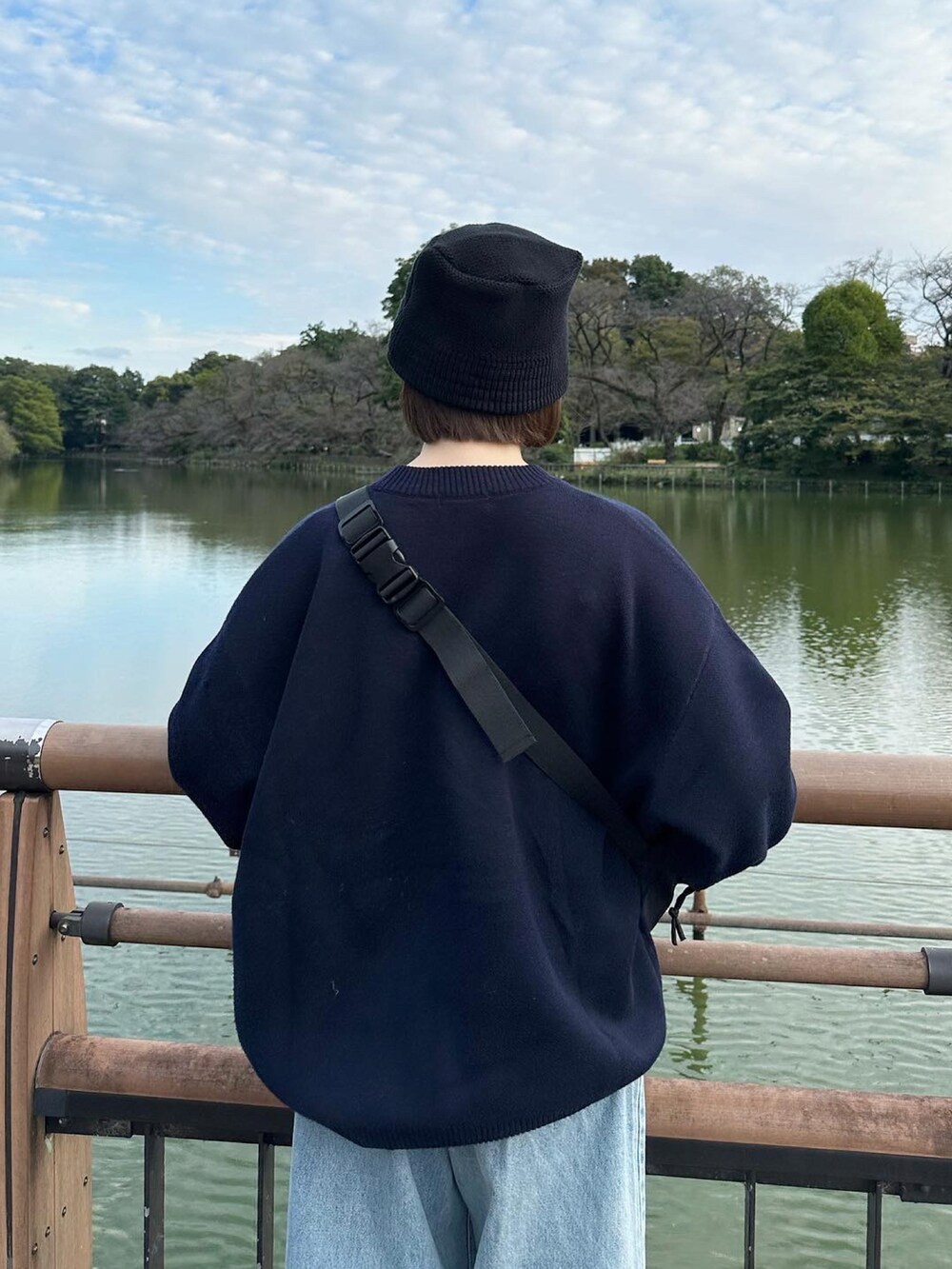 ブルー系のニット/セーター、ブルー系のデニムパンツ、ブラック系のスニーカーを着用したレディースの秋コーディネートの2枚目の写真