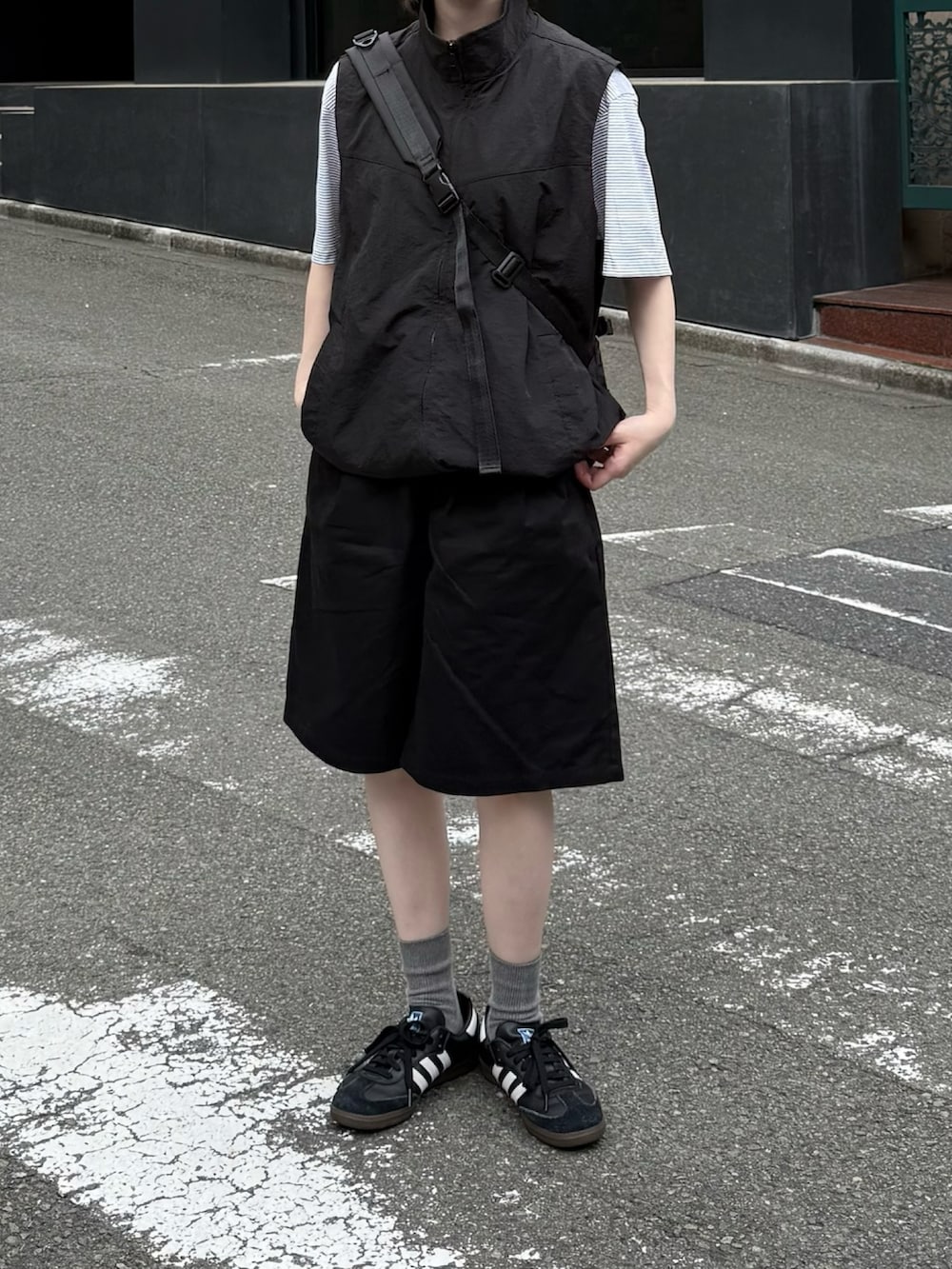 ブラック系のその他パンツ、ブラック系のベスト、ブラック系のショルダーバッグを着用したレディースの夏コーディネートの2枚目の写真