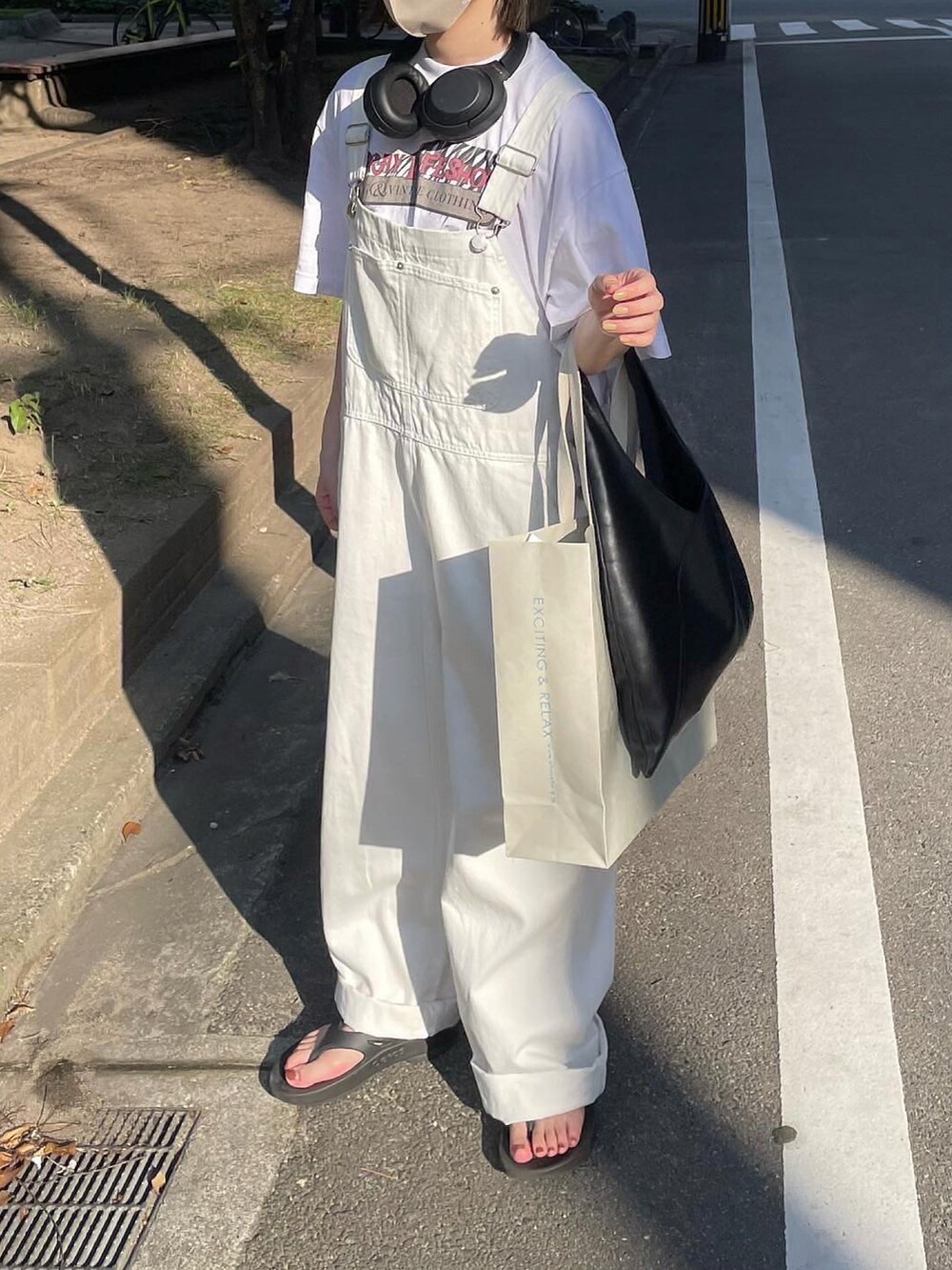 ホワイト系のサロペット/オーバーオール、ブラック系のサンダル、ブラック系のトートバッグを着用したレディースの夏コーディネートの2枚目の写真