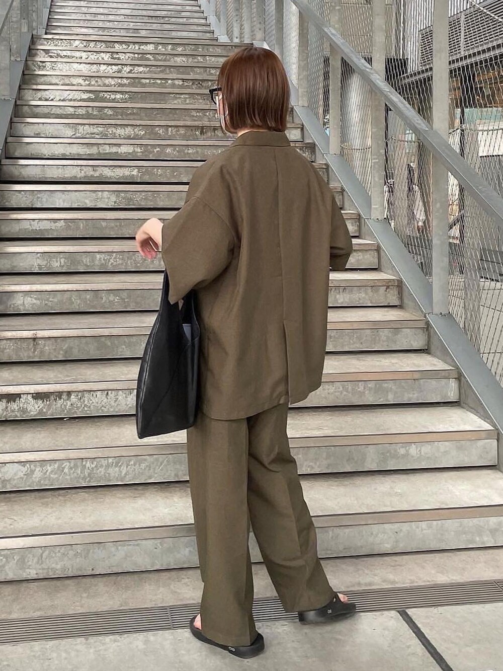 グリーン系のその他トップス、グリーン系のその他パンツ、ブラック系のトートバッグを着用したレディースの春コーディネートの2枚目の写真