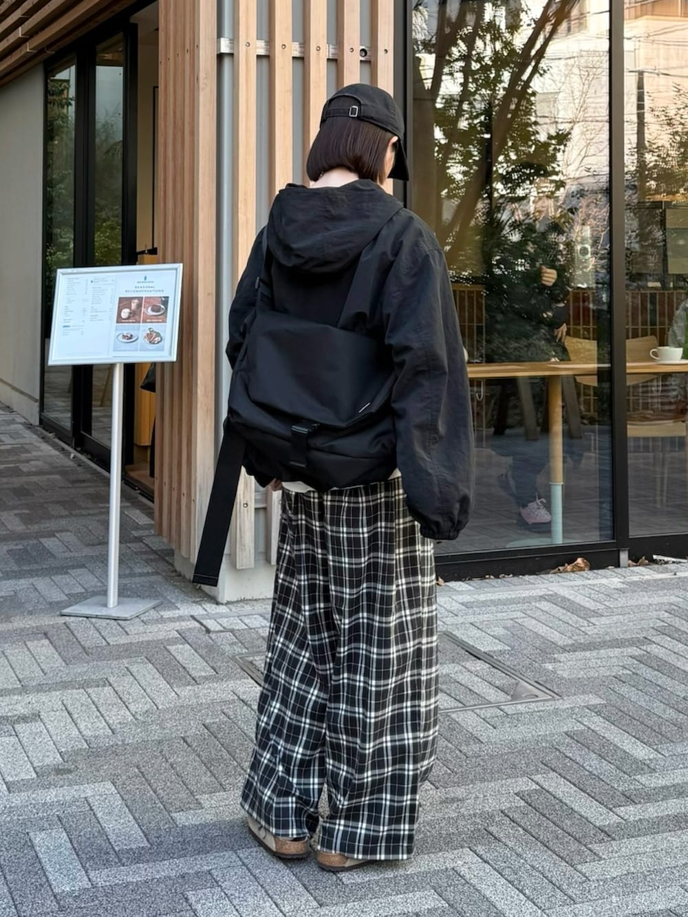 ブラック系のパーカー、ブラック系のその他パンツ、ブラック系のショルダーバッグを着用したレディースの冬コーディネートの2枚目の写真