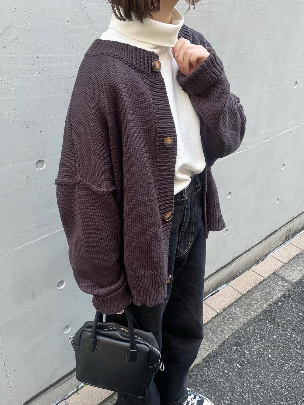 ブラウン系のカーディガン/ボレロ、ホワイト系のTシャツ/カットソー、ブラック系のデニムパンツを着用したレディースの秋コーディネートの2枚目の写真