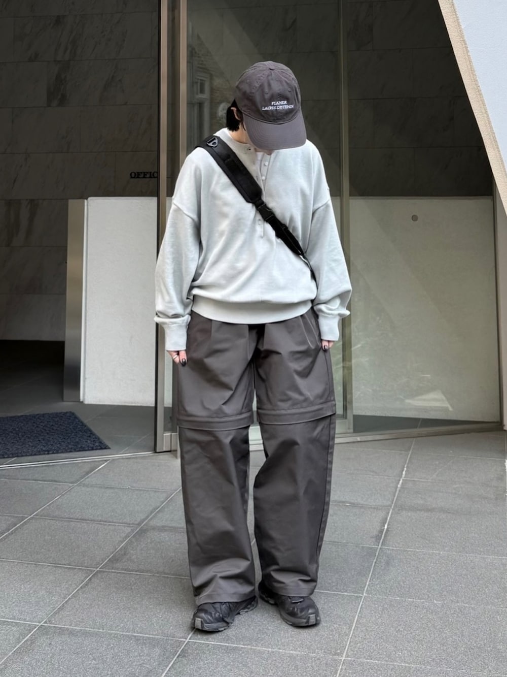 グレー系のニット/セーター、グレー系のその他パンツ、ブラック系のスニーカーを着用したレディースの春コーディネートの2枚目の写真