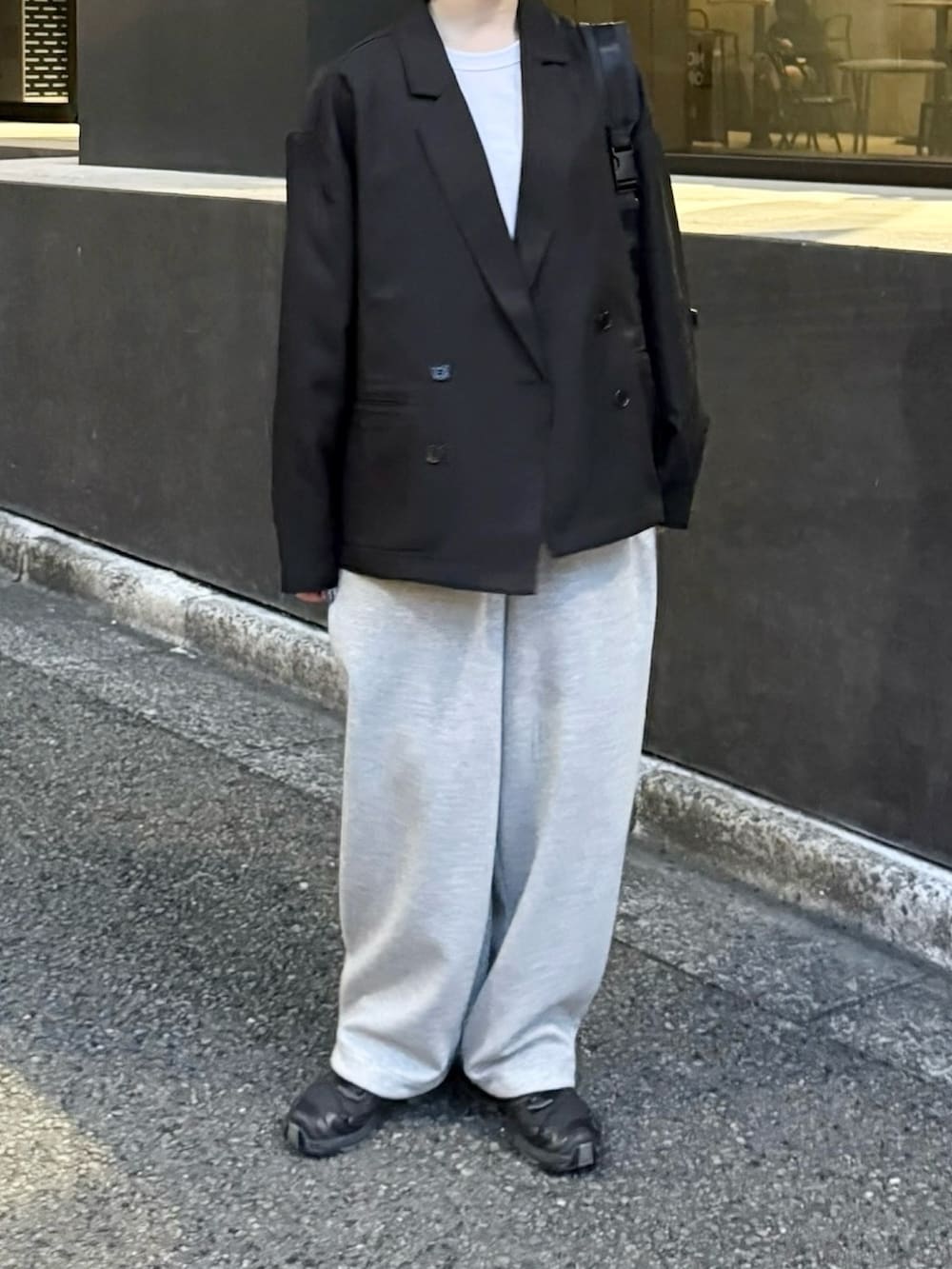 ブラック系のスニーカー、ブラック系のテーラードジャケット、グレー系のスウェットパンツを着用したレディースの秋コーディネートの2枚目の写真