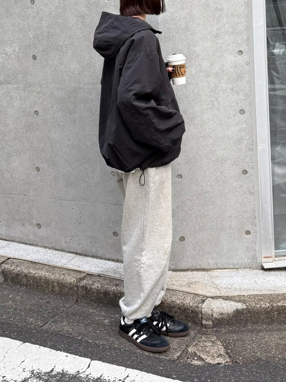 ブラック系のパーカー、グレー系のスウェットパンツ、ブラック系のスニーカーを着用したレディースの冬コーディネートの2枚目の写真