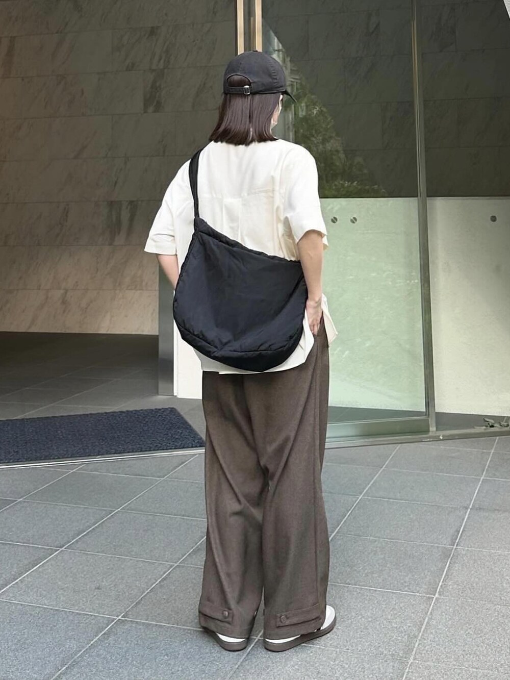 ホワイト系のシャツ/ブラウス、ブラウン系のスラックス、ブラック系のショルダーバッグを着用したレディースの夏コーディネートの3枚目の写真