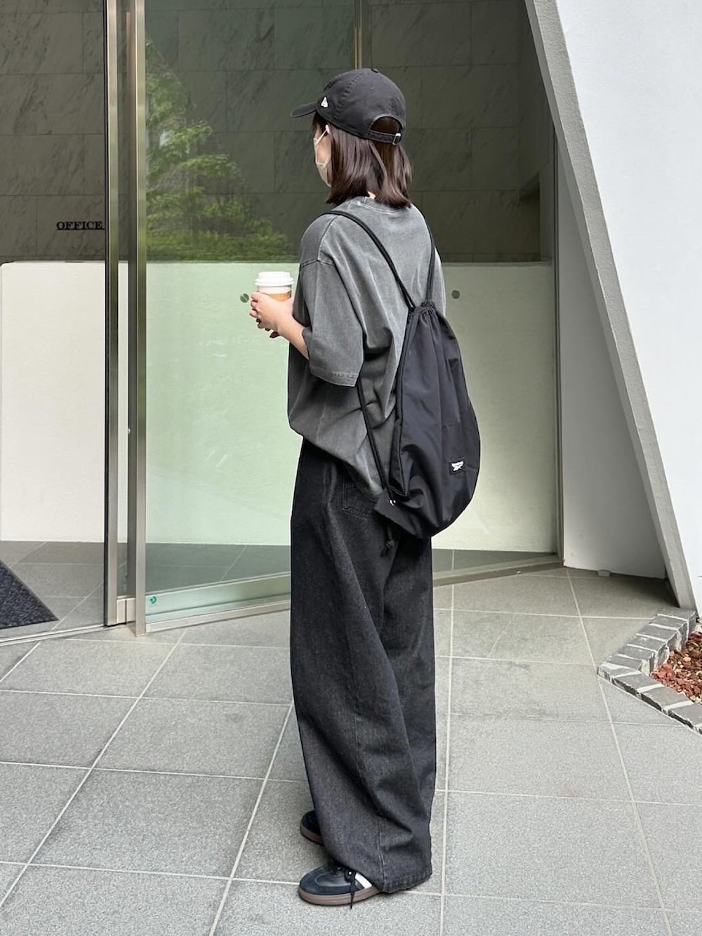 ブラック系のTシャツ/カットソー、ブラック系のデニムパンツ、ブラック系のショルダーバッグを着用したレディースの春コーディネートの2枚目の写真