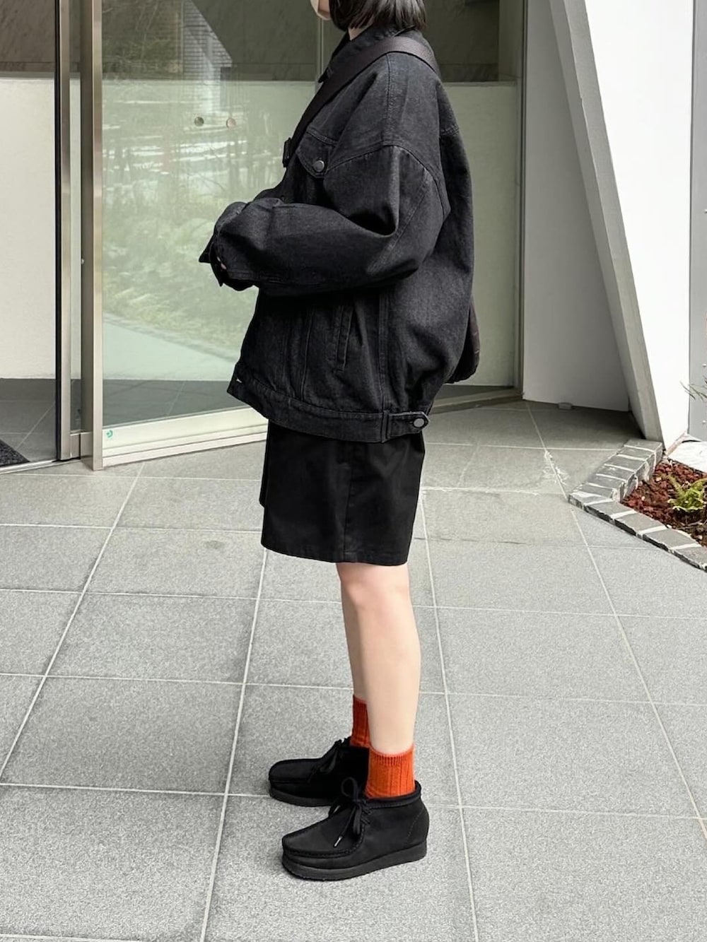 ブラック系のデニムジャケット、ブラック系のその他パンツ、ブラック系のショルダーバッグを着用したレディースの春コーディネートの3枚目の写真