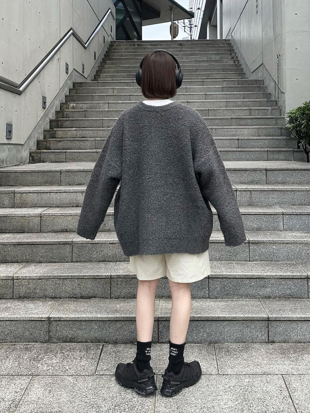 グレー系のカーディガン/ボレロ、ホワイト系のその他パンツ、ブラック系のスニーカーを着用したレディースの秋コーディネートの3枚目の写真