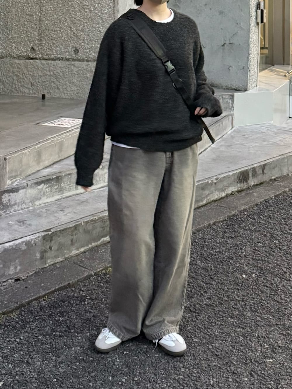 グレー系のニット/セーター、グレー系のデニムパンツ、ブラック系のショルダーバッグを着用したレディースの冬コーディネートの2枚目の写真