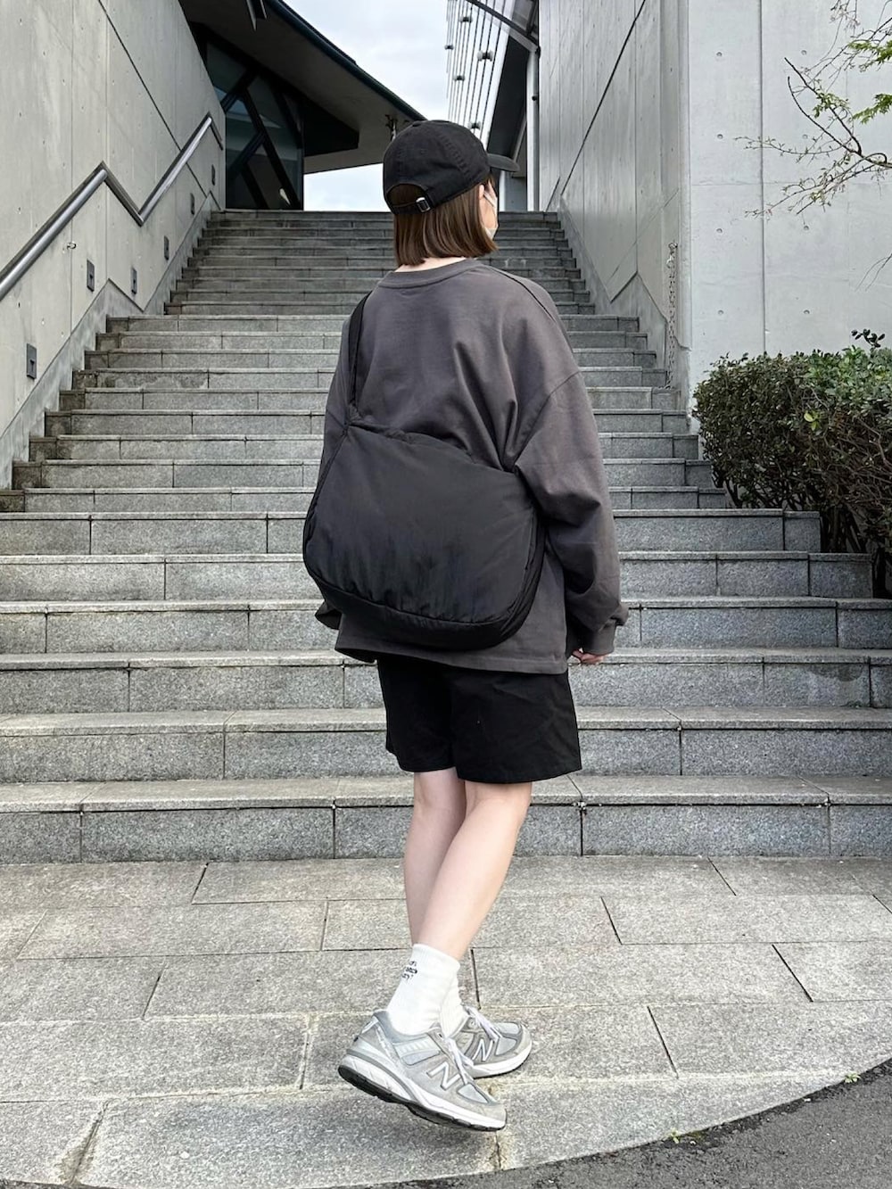 グレー系のTシャツ/カットソー、ブラック系のその他パンツ、ブラック系のショルダーバッグを着用したレディースの春コーディネートの2枚目の写真