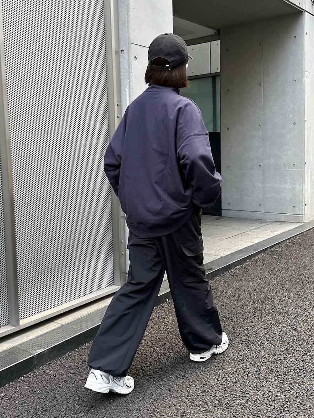 ブラック系のカーゴパンツ、ブルー系のスウェット、ホワイト系のスニーカーを着用したレディースの秋コーディネートの2枚目の写真