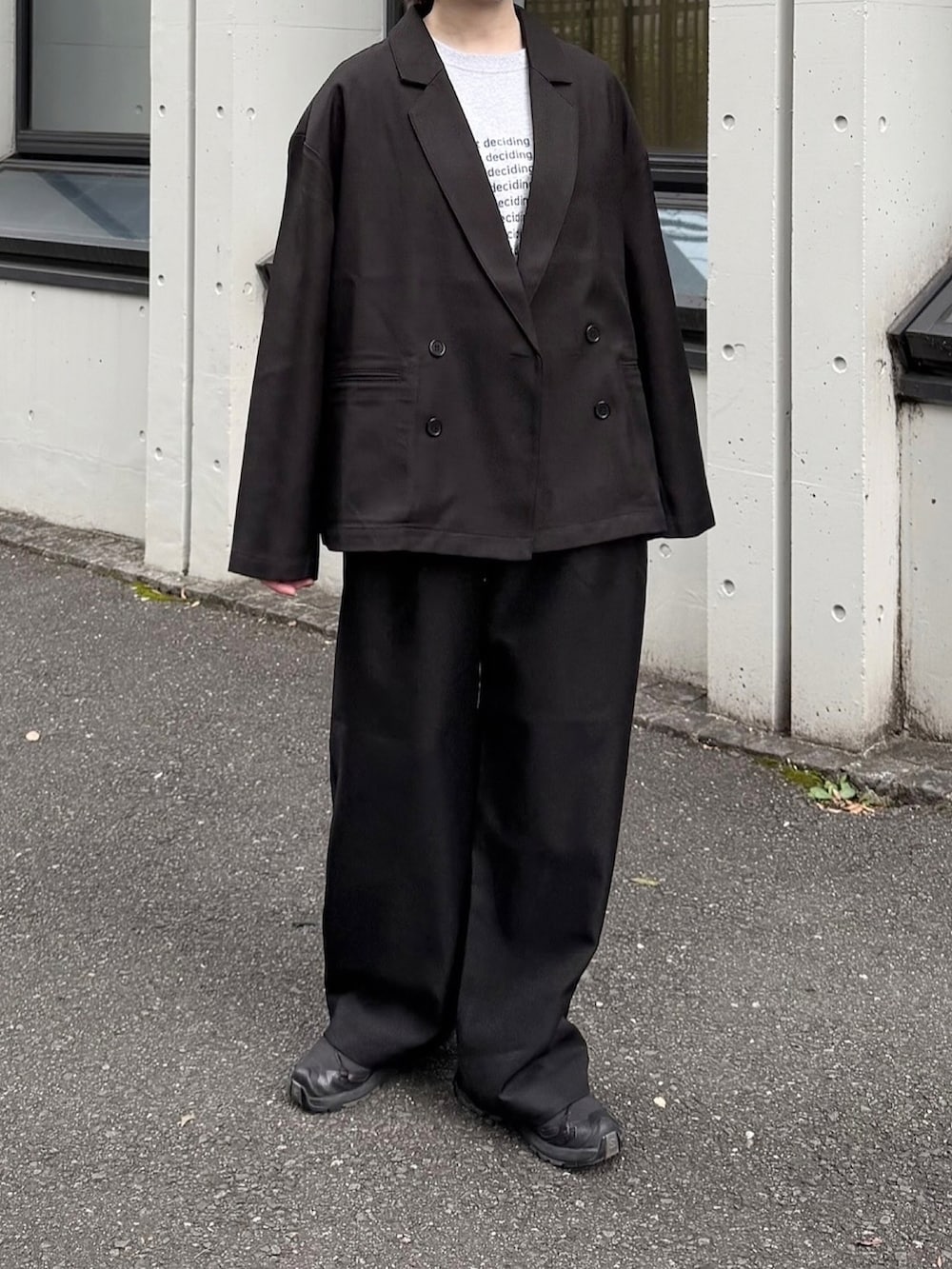 グレー系のTシャツ/カットソー、ブラック系のテーラードジャケット、ブラック系のスニーカーを着用したレディースの秋コーディネートの2枚目の写真