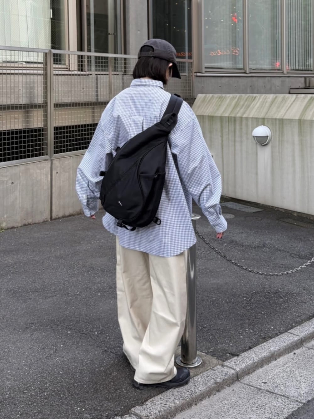 ブラック系のシャツ/ブラウス、ホワイト系のパンツ、ブラック系のショルダーバッグを着用したレディースの春コーディネートの2枚目の写真