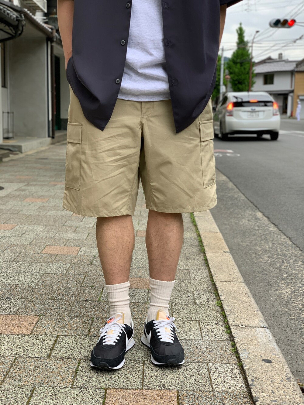 ベージュ系のカーゴパンツ、グレー系のシャツ/ブラウス、ブラック系のスニーカーを着用したメンズの夏コーディネートの4枚目の写真
