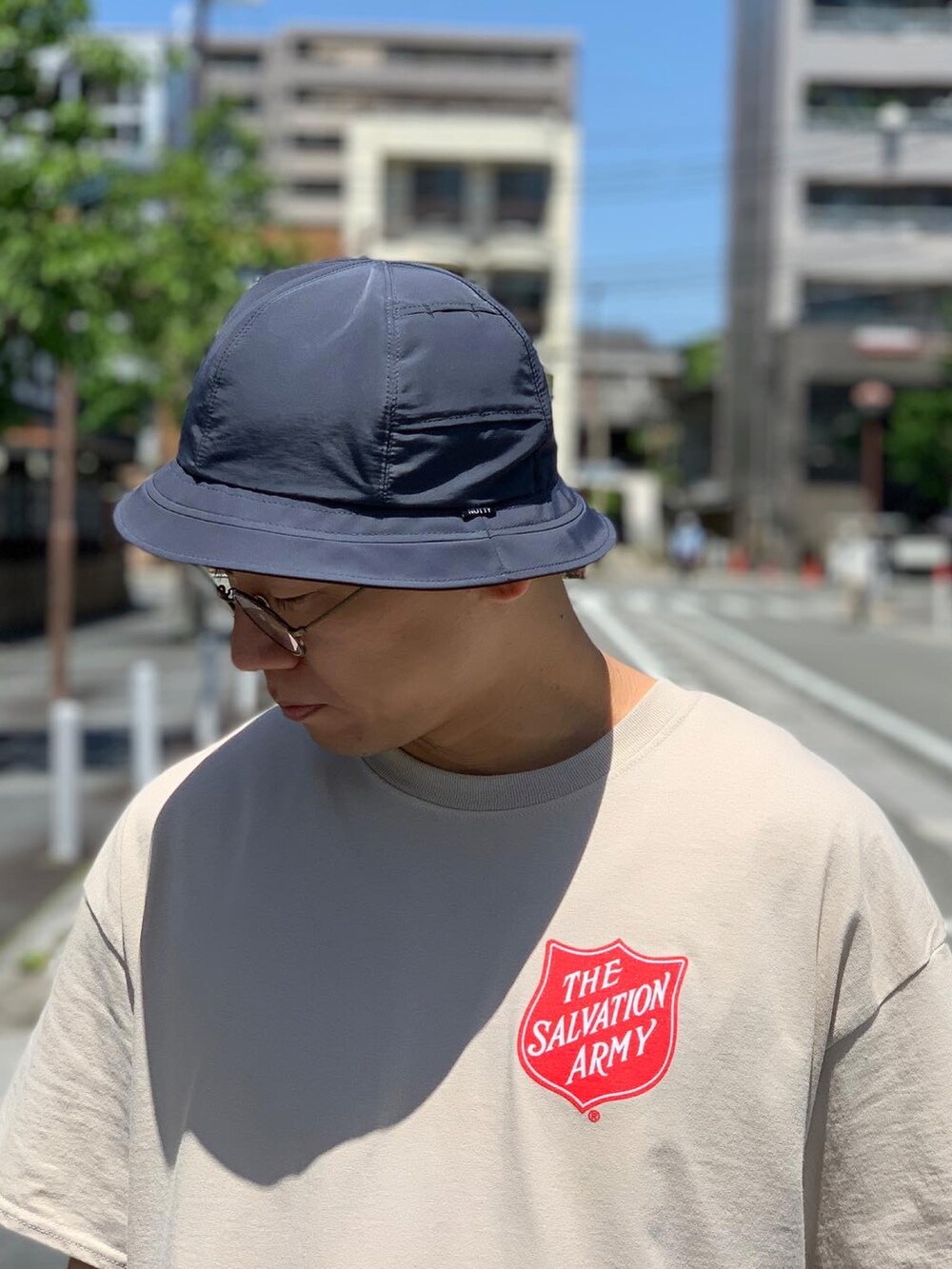 グリーン系のカーゴパンツ、ブラック系のスニーカー、ブラック系のハットを着用したメンズの夏コーディネートの3枚目の写真