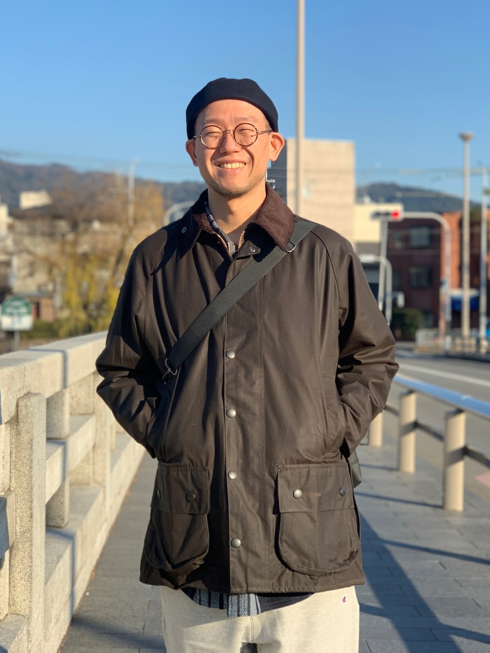 ブラウン系のジャケット/アウター、ブラック系のトートバッグ、グレー系のスウェットパンツを着用したメンズの冬コーディネートの3枚目の写真