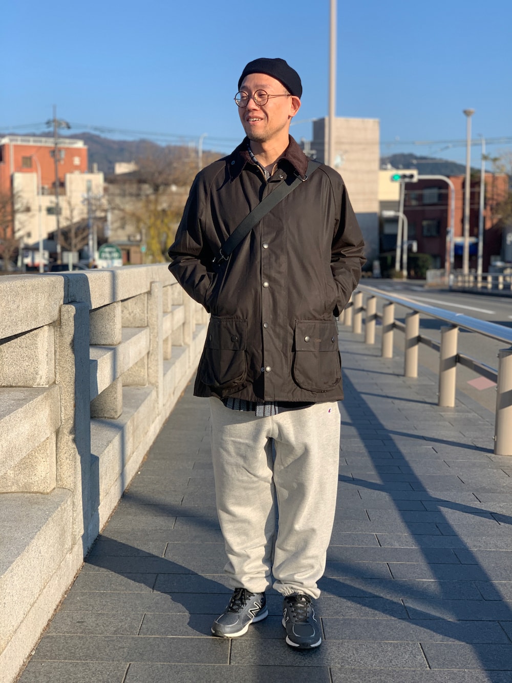 ブラウン系のジャケット/アウター、ブラック系のトートバッグ、グレー系のスウェットパンツを着用したメンズの冬コーディネートの2枚目の写真