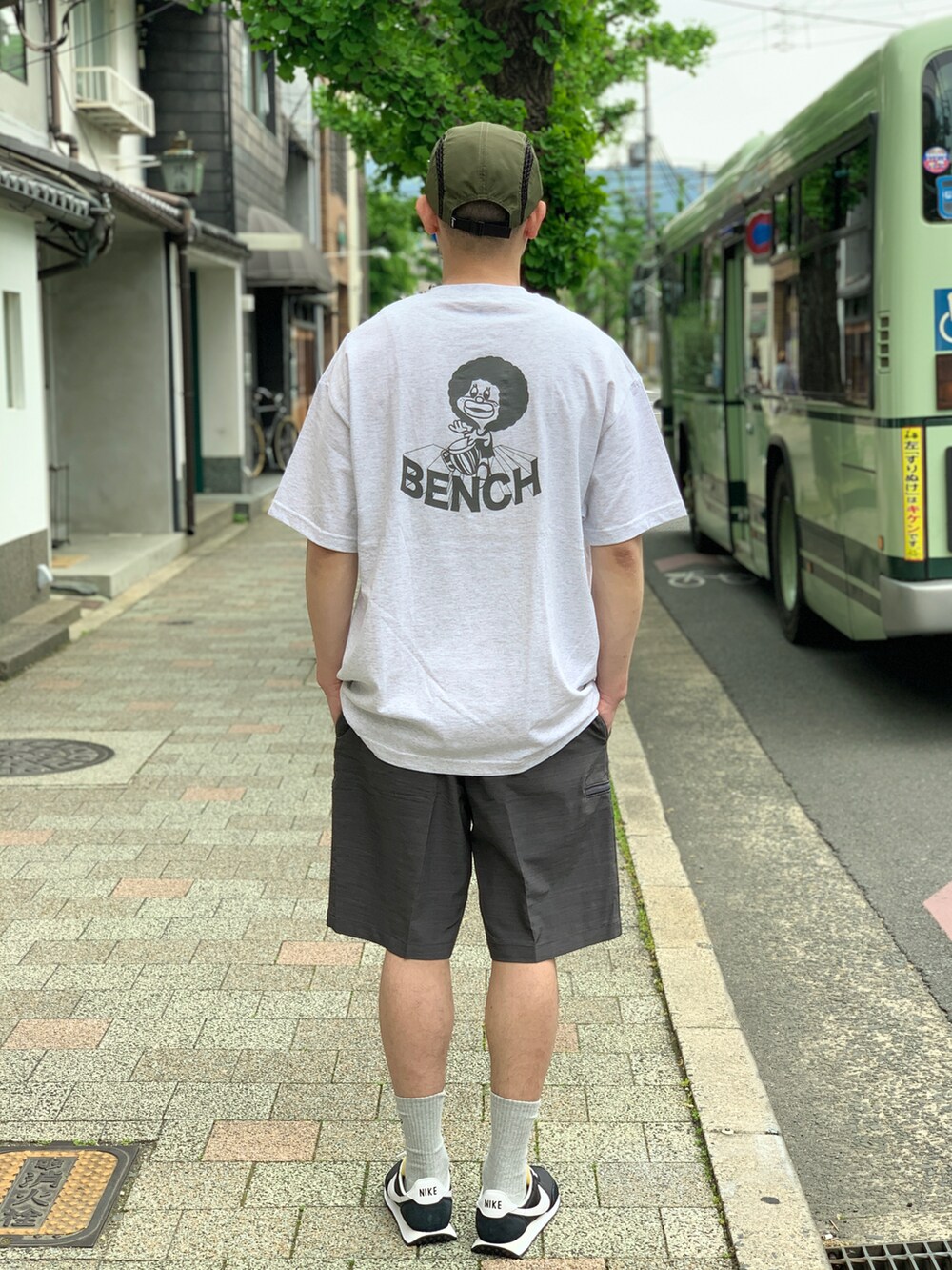 ブラック系のスニーカー、グレー系のチノパンツを着用したメンズの夏コーディネートの2枚目の写真