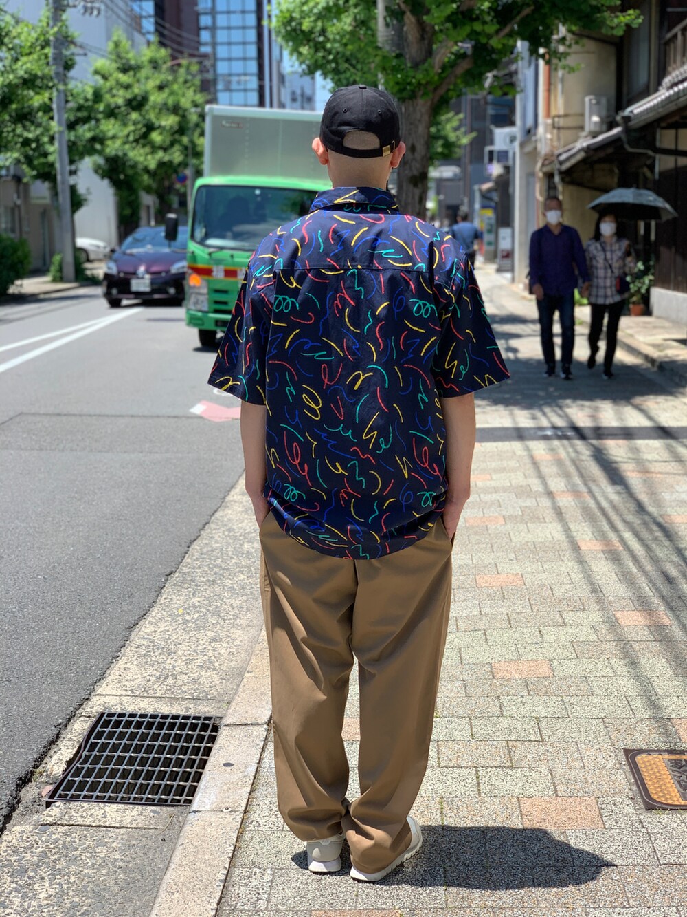 ベージュ系のチノパンツ、ブルー系のシャツ/ブラウス、ブラック系のキャップを着用したメンズの夏コーディネートの2枚目の写真