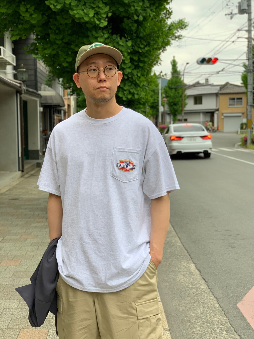 ベージュ系のカーゴパンツ、グレー系のシャツ/ブラウス、ブラック系のスニーカーを着用したメンズの夏コーディネートの5枚目の写真