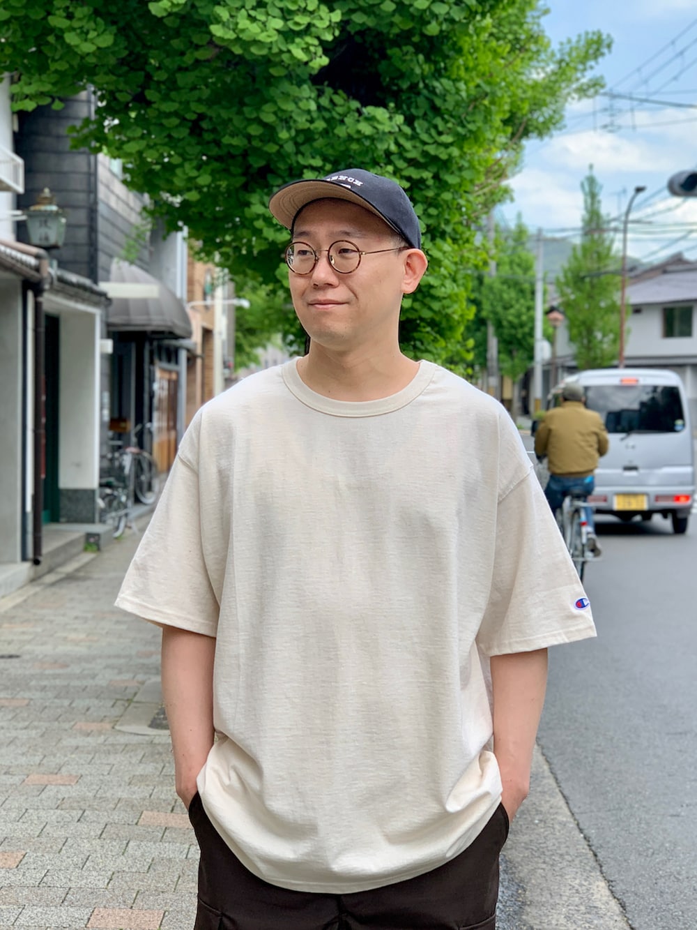 ブラウン系のカーゴパンツ、ベージュ系のTシャツ/カットソー、ブラック系のスニーカーを着用したメンズの夏コーディネートの2枚目の写真