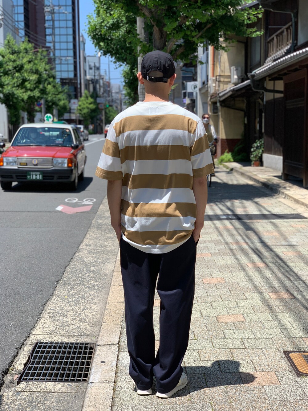 ブラウン系のTシャツ/カットソー、ブルー系のチノパンツ、ベージュ系のスニーカーを着用したメンズの夏コーディネートの2枚目の写真