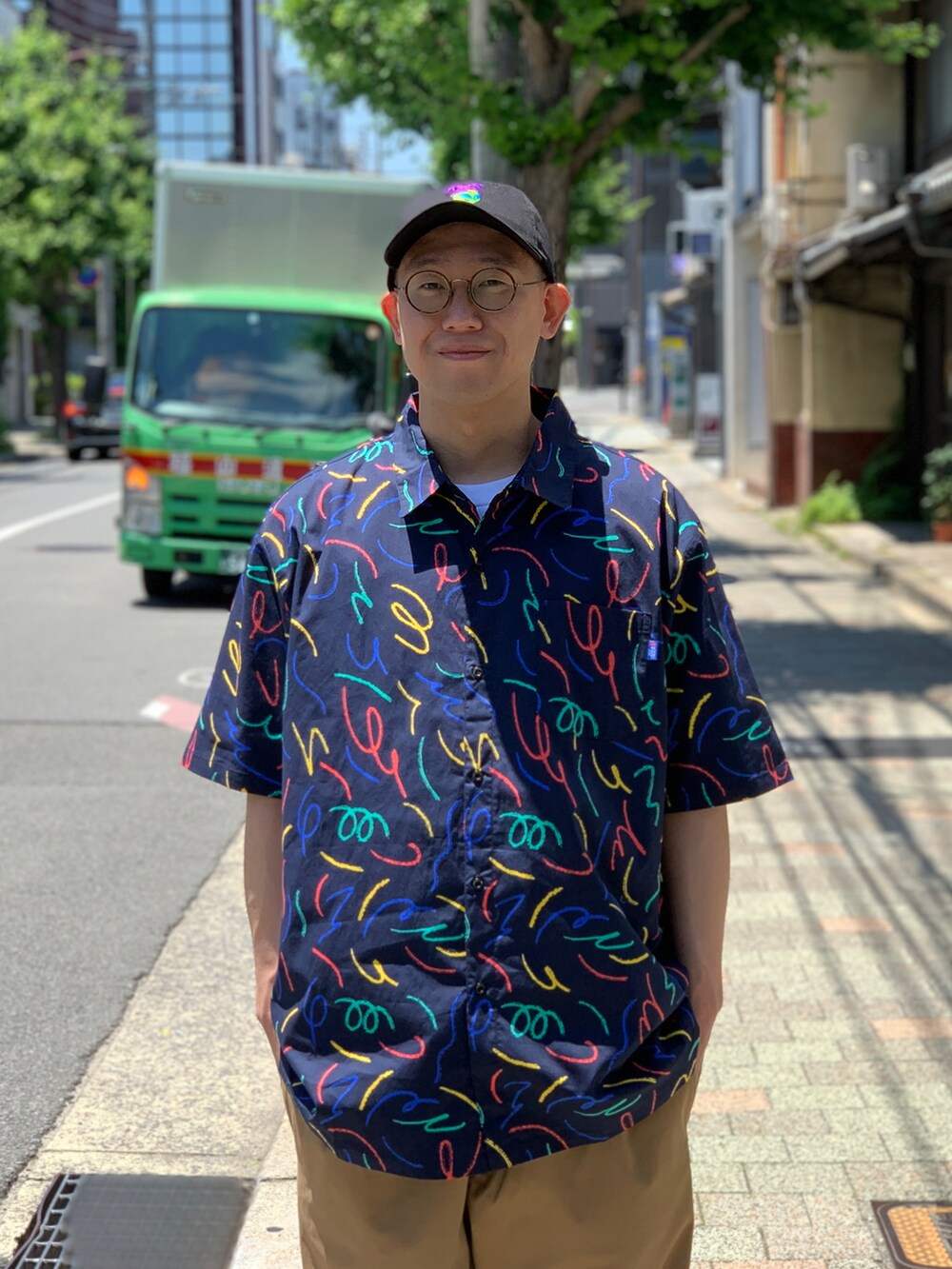 ベージュ系のチノパンツ、ブルー系のシャツ/ブラウス、ブラック系のキャップを着用したメンズの夏コーディネートの3枚目の写真