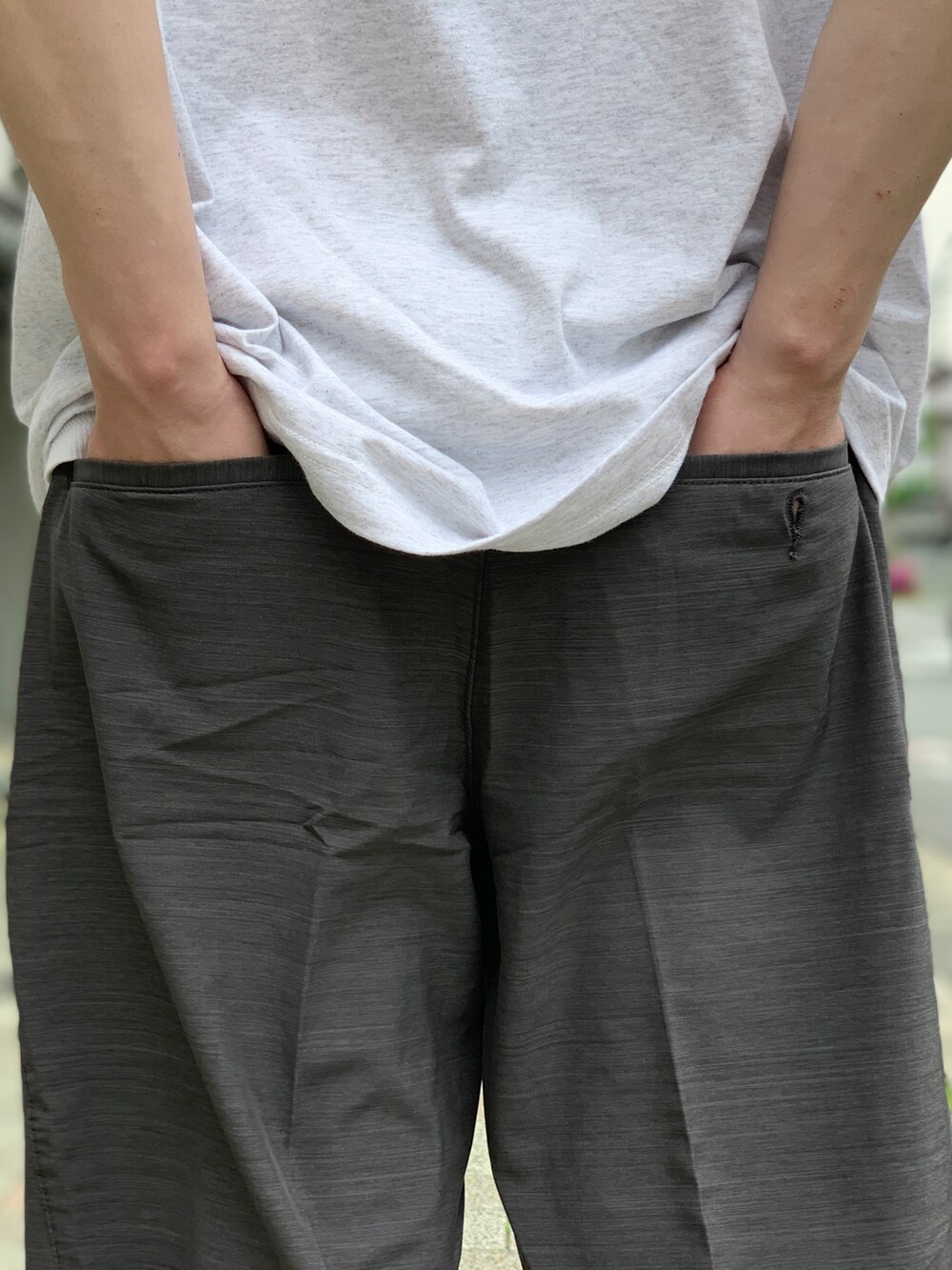 ブラック系のスニーカー、グレー系のチノパンツを着用したメンズの夏コーディネートの5枚目の写真