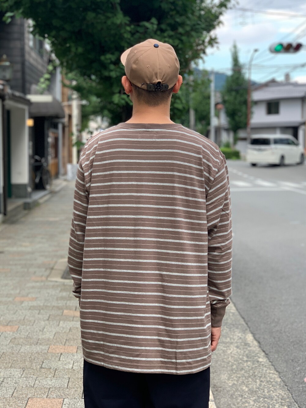 ブルー系のチノパンツ、ブラウン系のTシャツ/カットソーを着用したメンズの秋コーディネートの4枚目の写真